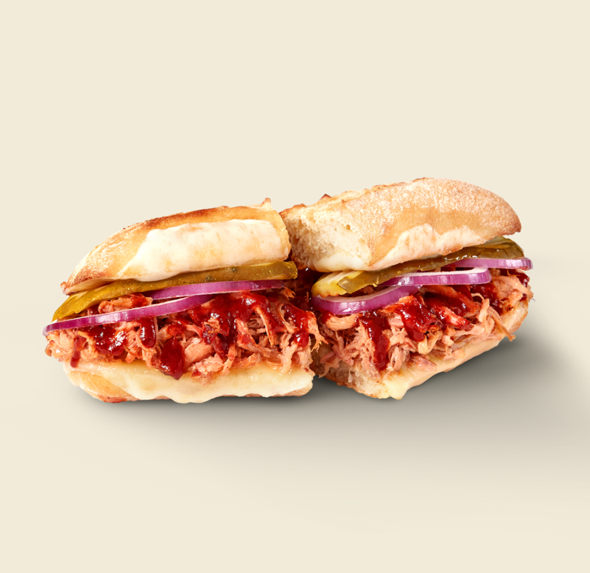 A savory BBQ Pulled Pork Sandwich piled high with tender pulled pork, melted cheese, pickles, red onions, and rich barbecue sauce on toasted artisan bread.
