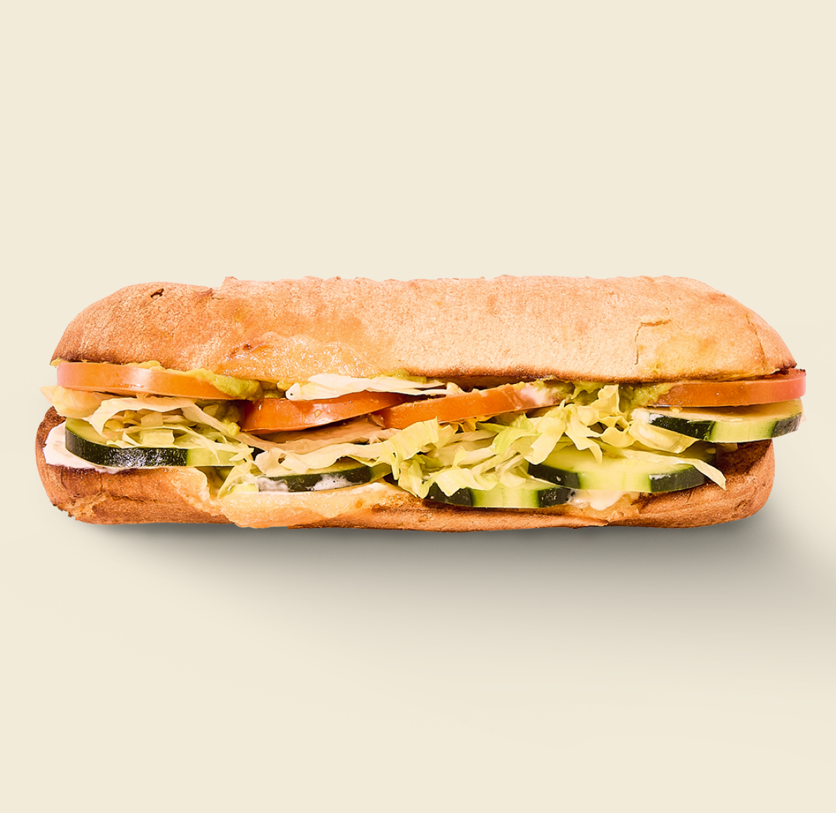 The Veggie Sandwich, layered with crisp cucumbers, juicy tomatoes, shredded lettuce, and creamy house dressing on freshly baked artisan bread.