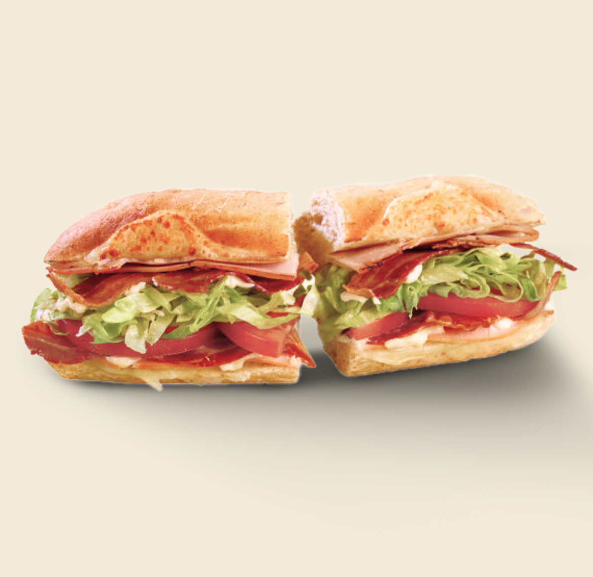 The Turkey Bacon Sandwich, layered with sliced turkey, crispy bacon, fresh lettuce, juicy tomatoes, and creamy mayo on freshly baked artisan bread.