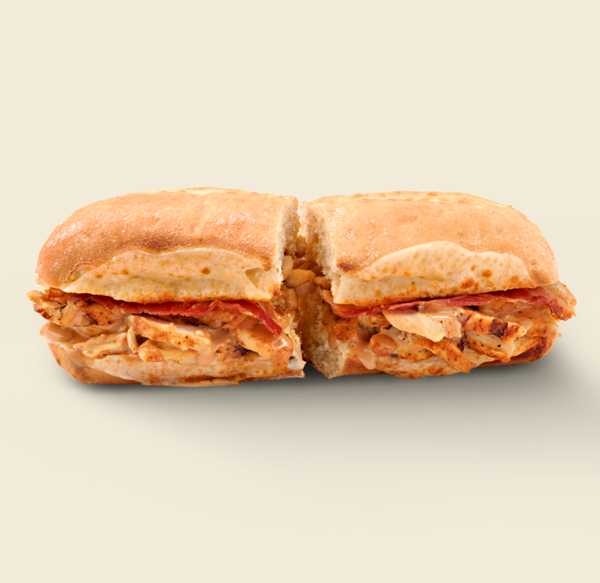 The Asiago Chicken Sandwich, featuring grilled chicken, crispy bacon, melted asiago cheese, and creamy ranch dressing on freshly baked artisan bread.