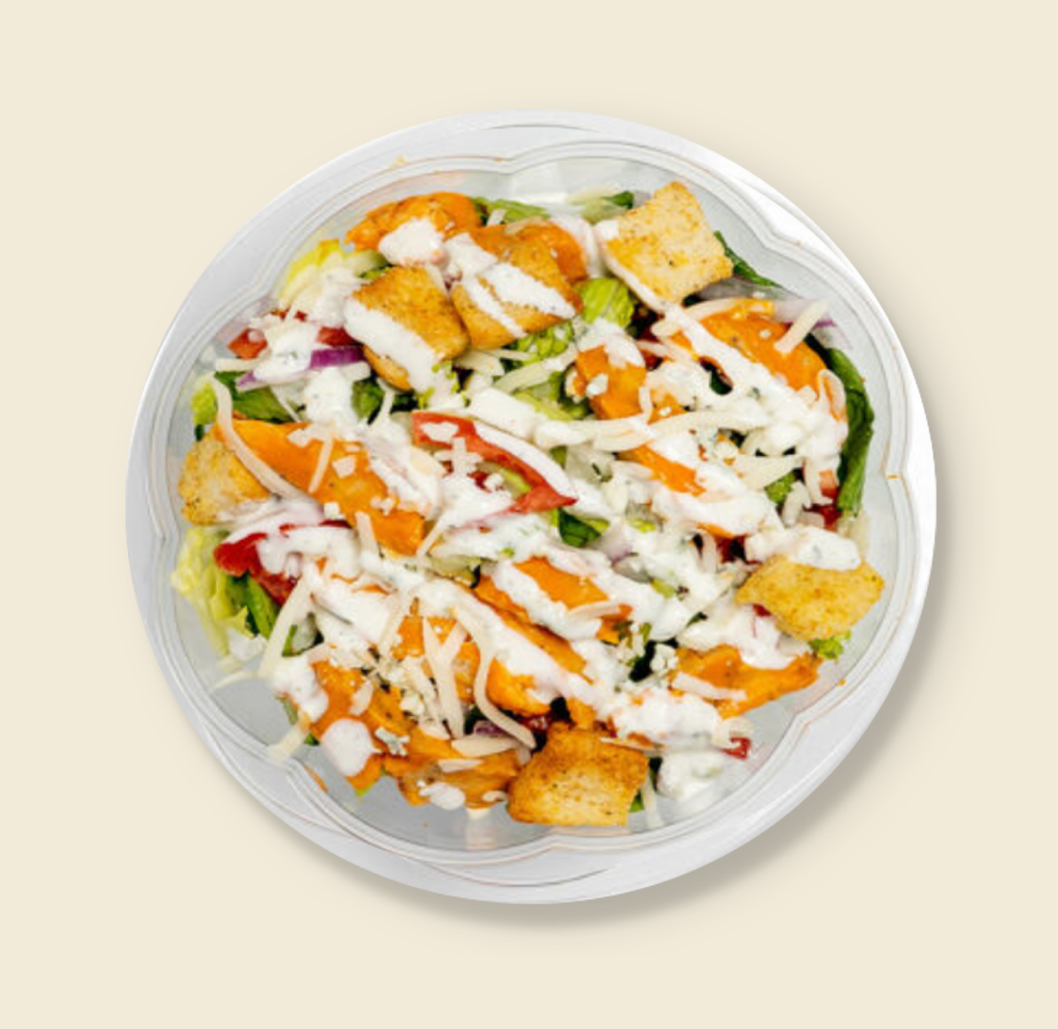 A fresh buffalo chicken salad topped with crispy chicken, shredded cheese, croutons, and drizzled with ranch dressing in a clear plastic container.