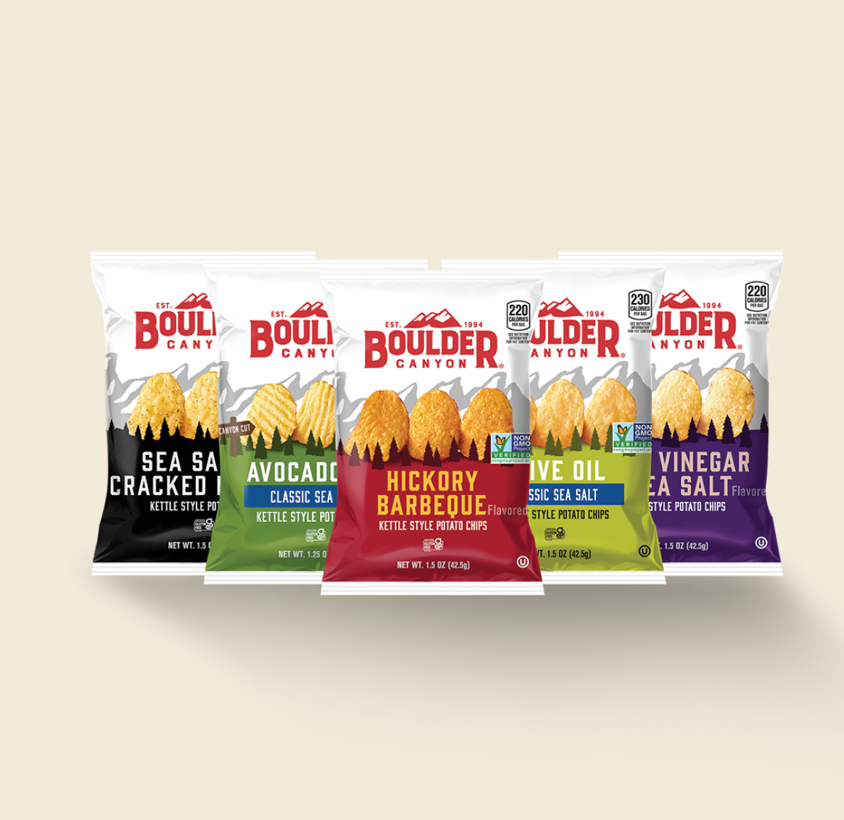 A variety of Boulder Canyon kettle-style potato chips in five flavors, including Sea Salt & Cracked Pepper, Avocado Oil Classic Sea Salt, Hickory Barbeque, Olive Oil Classic Sea Salt, and Malt Vinegar & Sea Salt, arranged on a light background.