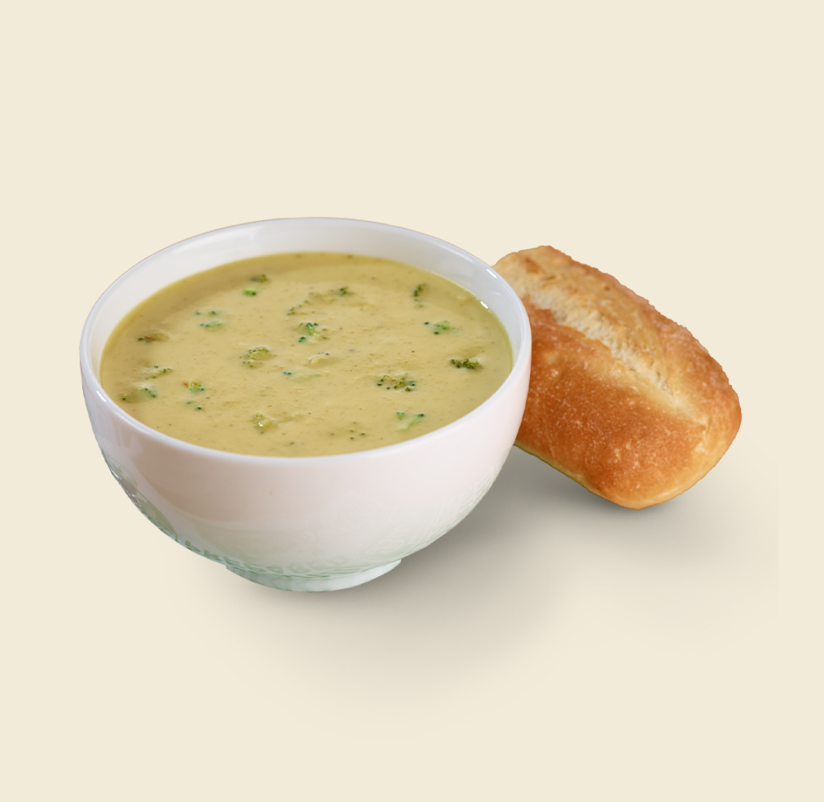 A bowl of broccoli cheese soup with chunks of broccoli, served alongside a crusty soup roll on a light background.