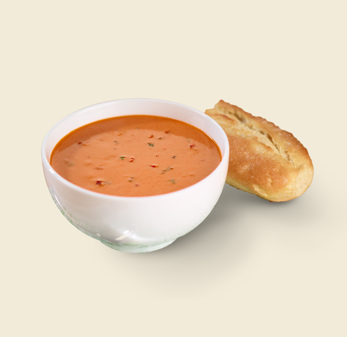 A bowl of tomato basil soup with visible herbs, served alongside a crusty soup roll on a light background.
